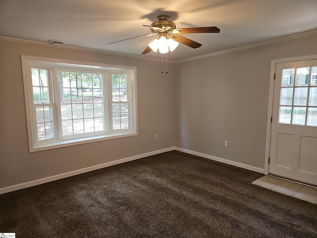 spare room featuring a ceiling fan, ornamental molding, dark carpet, and baseboards