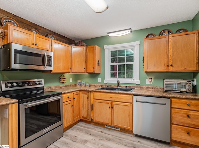 1312 Anderson Hwy, Easley, SC 29642 - kitchen featuring stainless steel appliances, a sink, light wood-style floors, and a textured ceiling