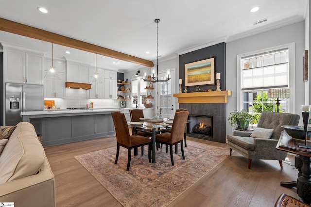 114 Burrough St, Greenville, SC 29615 - dining room with light wood-style floors, ornamental molding, recessed lighting, a tiled fireplace, and a chandelier