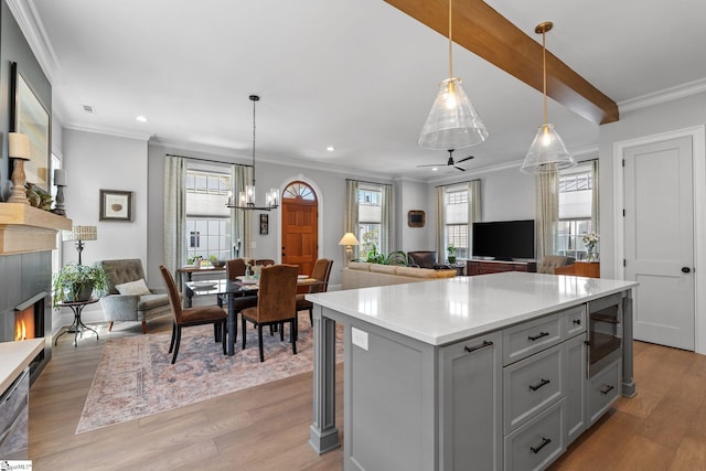 114 Burrough St, Greenville, SC 29615 - kitchen with gray cabinetry, built in microwave, light countertops, light wood-type flooring, and ornamental molding
