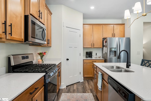 kitchen featuring stainless steel appliances, a sink, dark wood-type flooring, recessed lighting, and a center island with sink