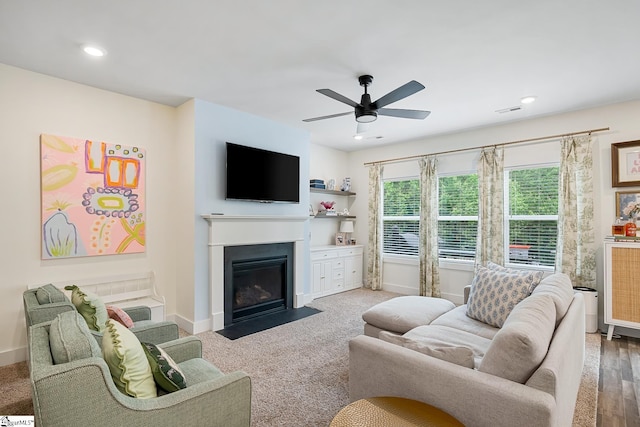 living area featuring a fireplace with flush hearth, a ceiling fan, baseboards, and recessed lighting