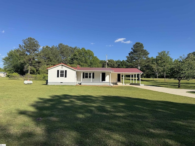 view of front of house featuring a front lawn, concrete driveway, crawl space, and view of wooded area