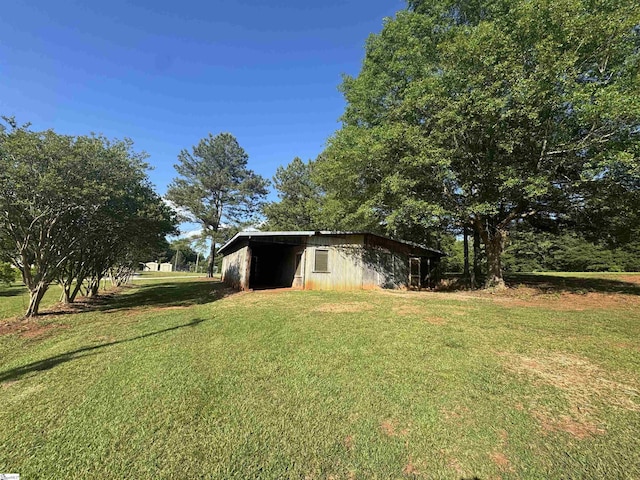 view of grassy yard with an outdoor structure