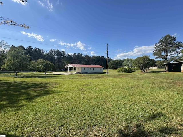 view of grassy yard featuring a carport