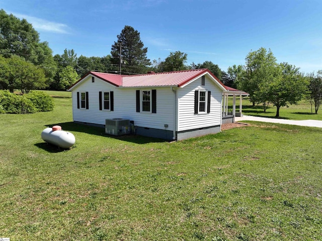 view of home's exterior with crawl space, a yard, metal roof, and central AC unit