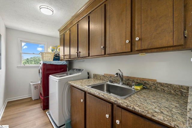 205 Woodfield Dr, Piedmont, SC 29673 - laundry area featuring separate washer and dryer, cabinet space, light wood finished floors, baseboards, and a textured ceiling