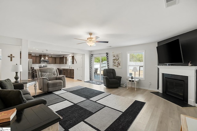 121 Frost Flower Way, Fountain Inn, SC 29644 - living area with light wood-style flooring, ceiling fan, a fireplace with flush hearth, baseboards, and recessed lighting