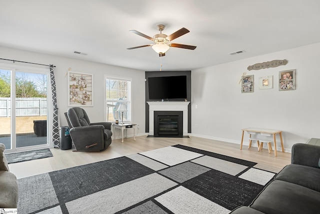 121 Frost Flower Way, Fountain Inn, SC 29644 - living room featuring a ceiling fan, light wood-style flooring, a fireplace with flush hearth, and baseboards