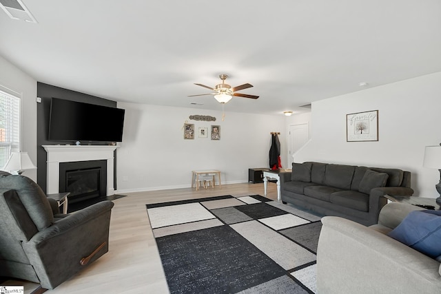 121 Frost Flower Way, Fountain Inn, SC 29644 - living area featuring a ceiling fan, light wood-style flooring, a fireplace with flush hearth, and baseboards