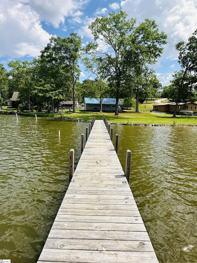 dock featuring a water view and a lawn
