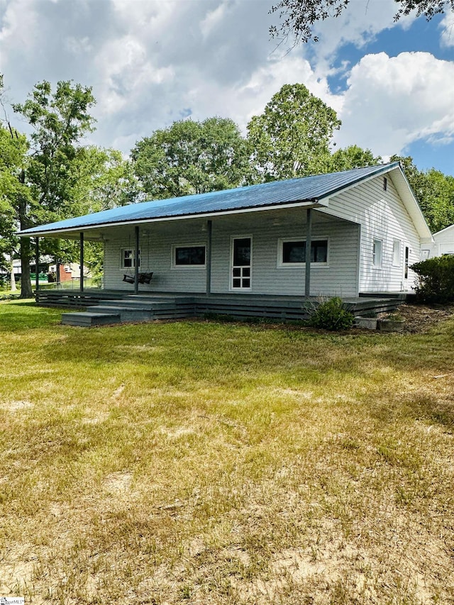 rear view of property featuring a yard