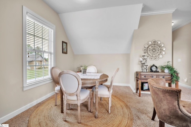 dining area featuring carpet flooring, baseboards, lofted ceiling, and ornamental molding