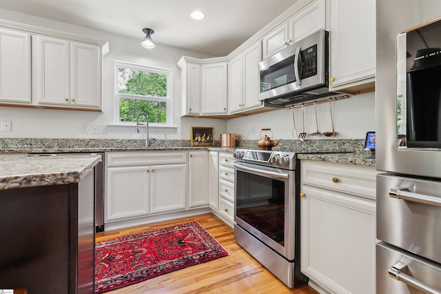 31 Goodwin Farms Ct, Travelers Rest, SC 29690 - kitchen with appliances with stainless steel finishes, a sink, light wood-type flooring, white cabinets, and light stone counters