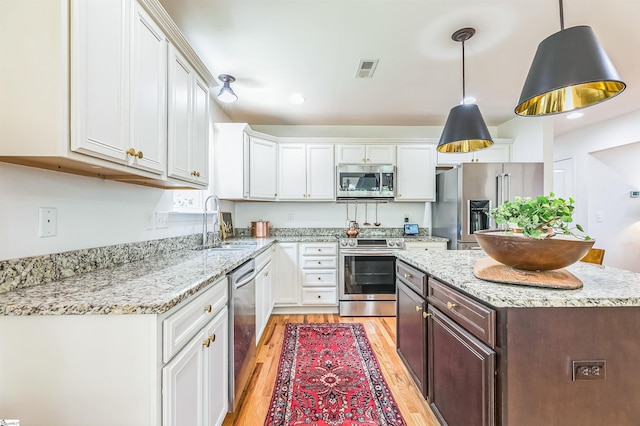 31 Goodwin Farms Ct, Travelers Rest, SC 29690 - kitchen with stainless steel appliances, a sink, light wood finished floors, white cabinetry, and recessed lighting