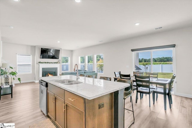 204 Hazelcroft Dr, Fountain Inn, SC 29644 - kitchen featuring a sink, dishwasher, a center island with sink, light wood-style floors, and light stone countertops