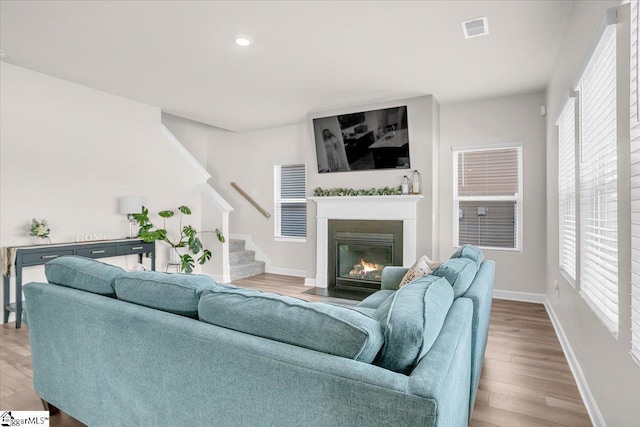 204 Hazelcroft Dr, Fountain Inn, SC 29644 - living area with stairway, a fireplace with flush hearth, wood finished floors, healthy amount of natural light, and recessed lighting