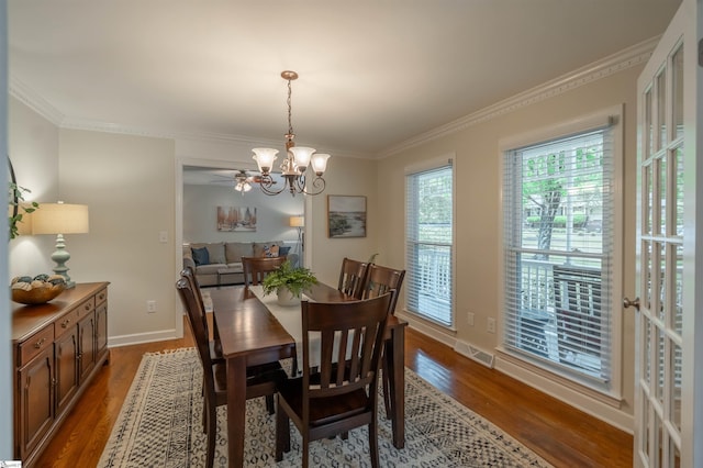 dining space with a chandelier, wood finished floors, ornamental molding, and baseboards