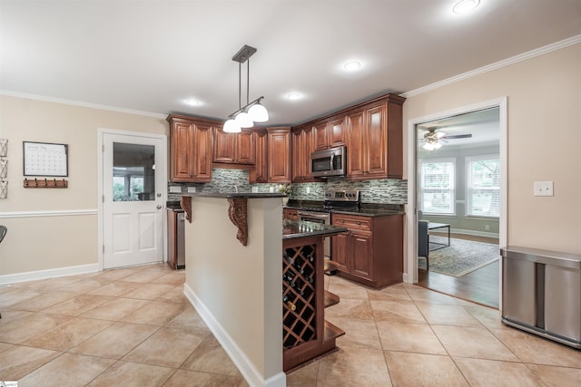 kitchen featuring appliances with stainless steel finishes, ornamental molding, dark countertops, decorative backsplash, and decorative light fixtures