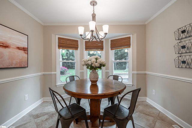 dining room featuring a chandelier, ornamental molding, and baseboards