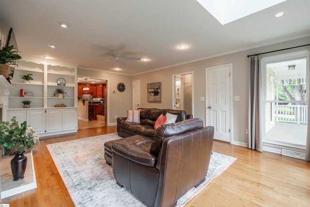 living room with ornamental molding, light wood finished floors, a ceiling fan, recessed lighting, and baseboards