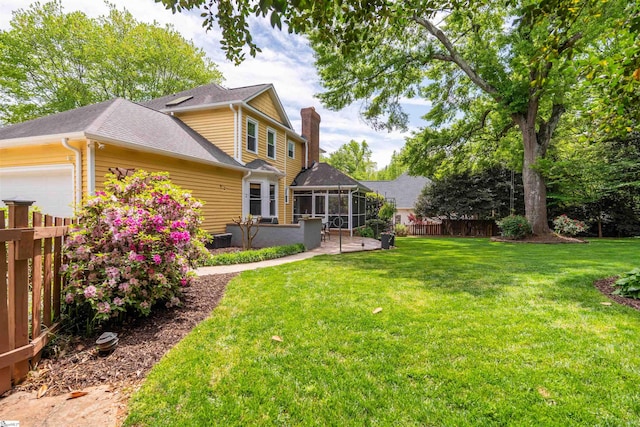 view of yard featuring a sunroom and an attached garage