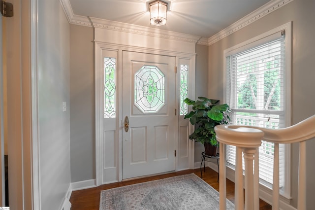 entryway with wood finished floors, ornamental molding, and baseboards