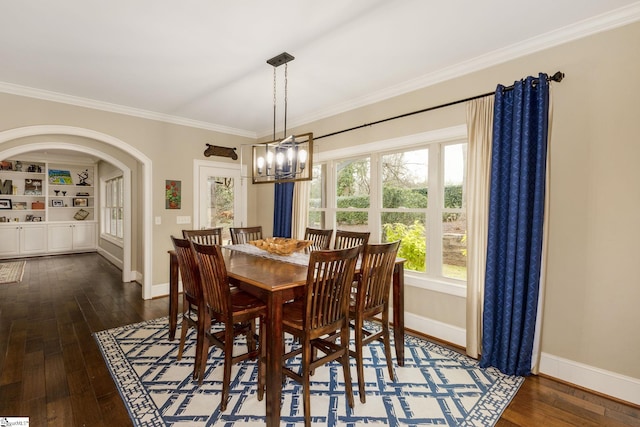 15 Paddington Ave, Greenville, SC 29609 - dining area featuring crown molding, baseboards, dark wood-style floors, arched walkways, and a chandelier