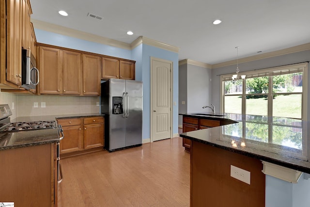 9 Sheldrake Pl, Simpsonville, SC 29681 - kitchen with stainless steel appliances, a sink, light wood-style floors, crown molding, and tasteful backsplash