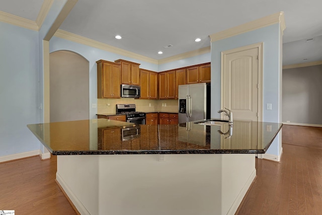 9 Sheldrake Pl, Simpsonville, SC 29681 - kitchen featuring stainless steel appliances, a sink, wood finished floors, tasteful backsplash, and a large island