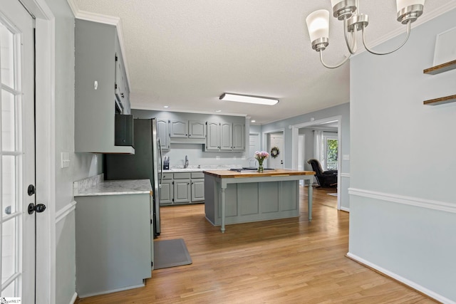 202 Shadow Oaks Dr, Easley, SC 29642 - kitchen with gray cabinetry, wood counters, a sink, light wood finished floors, and a chandelier