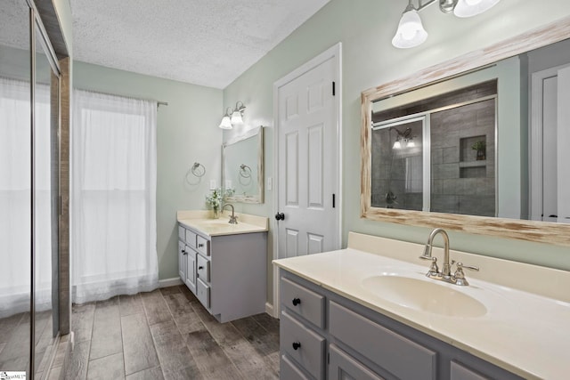 202 Shadow Oaks Dr, Easley, SC 29642 - full bath featuring a shower stall, wood finished floors, two vanities, and a textured ceiling
