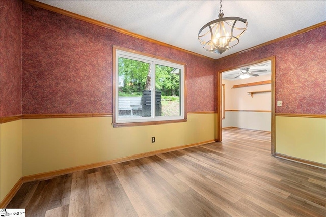 1606 Winding Way, Taylors, SC 29687 - empty room with a chandelier, wood finished floors, ornamental molding, wallpapered walls, and baseboards