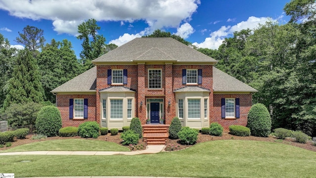 colonial house with brick siding and a shingled roof
