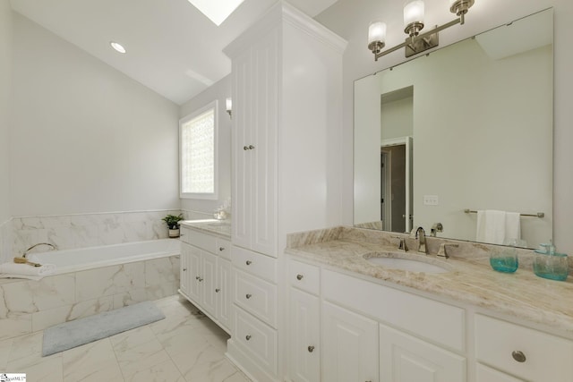 full bath featuring marble look tile flooring, vanity, and a garden tub