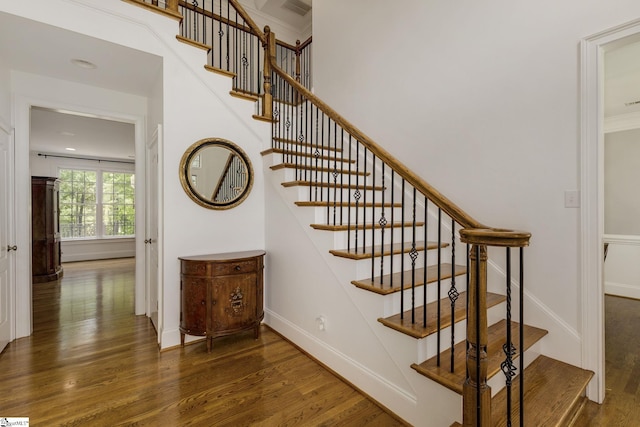 staircase with wood finished floors and baseboards