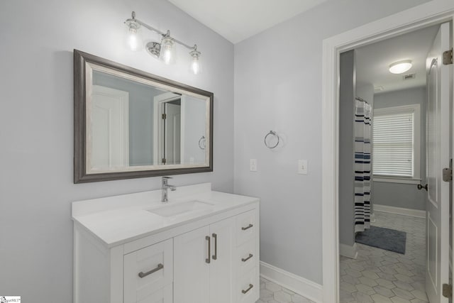 bathroom featuring vanity, tile patterned flooring, and baseboards