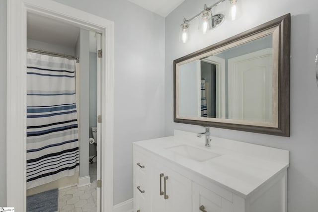 full bathroom featuring baseboards, vanity, and toilet