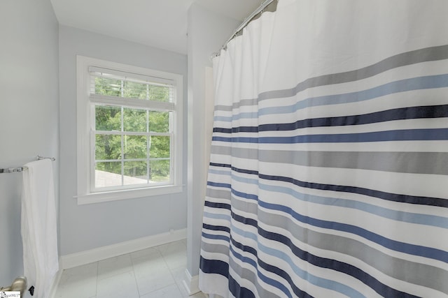 full bathroom featuring baseboards and curtained shower