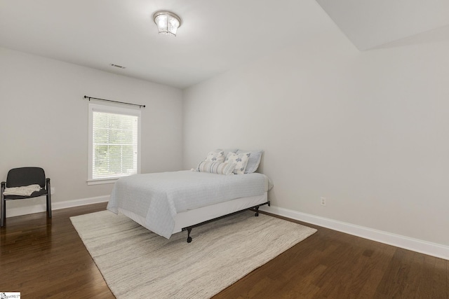 bedroom with dark wood finished floors and baseboards