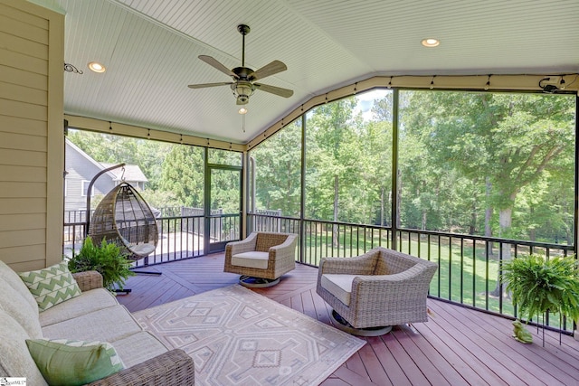 sunroom / solarium with lofted ceiling, a ceiling fan, an outdoor living space, and plenty of natural light