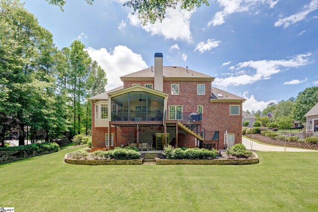 back of house with stairway, a sunroom, brick siding, ceiling fan, and a yard
