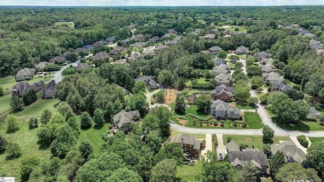 aerial view of property's location featuring a heavily wooded area and nearby suburban area