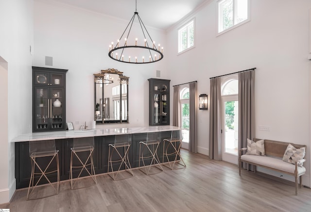 7 Collina Ct, Greenville, SC 29609 - indoor bar with wood finished floors, a chandelier, a towering ceiling, crown molding, and baseboards