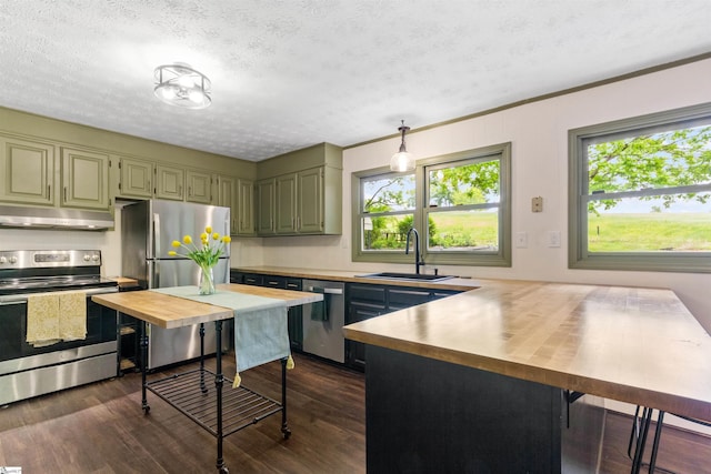 kitchen with stainless steel appliances, under cabinet range hood, a sink, dark wood-style floors, and a textured ceiling
