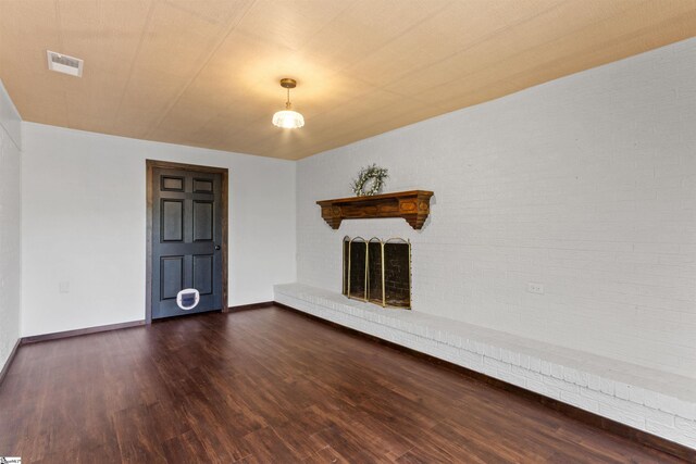 unfurnished living room featuring a fireplace, dark wood finished floors, and baseboards