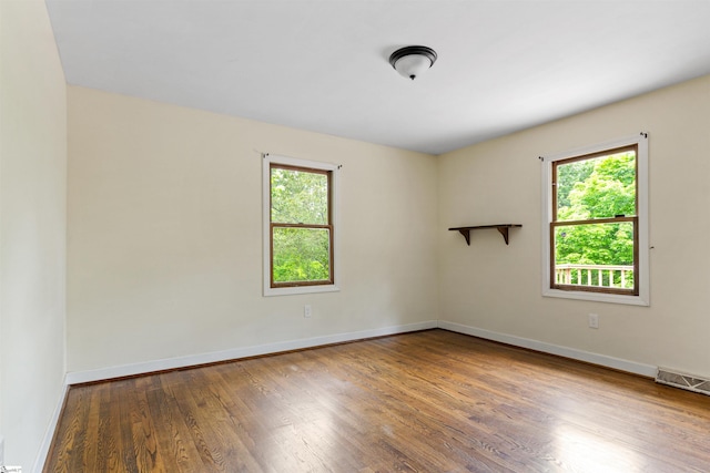 spare room featuring wood finished floors and baseboards