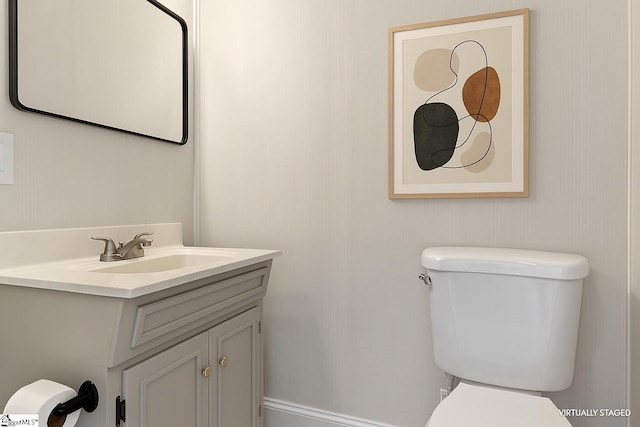 half bathroom featuring vanity and toilet
