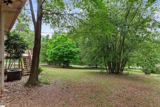 view of yard featuring central AC and stairway