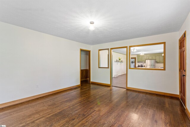spare room with wood finished floors and baseboards